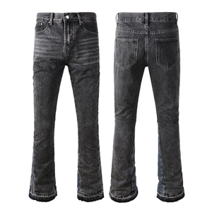 Detail view of washed black flare jeans with cat-whisker fading and raw hem edges