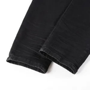 Detailed close-up of dark wash denim hems with reinforced stitching and twill texture