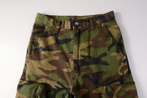 Detail view of army green camouflage cargo pants with sturdy waist buttons and deep pockets