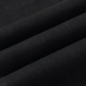 Macro shot of high-density black denim fabric showing detailed twill texture and weaving
