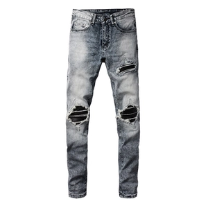 Detail showing distressed motorcycle style knee patches on grey slim fit men jeans