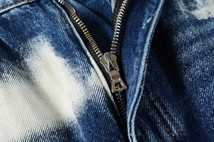Detailed close-up of the high-quality metal zipper on these vintage washed cargo jeans