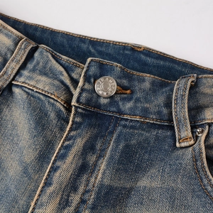 Close-up of vintage blue denim jeans waistband with metallic button and contrast stitching