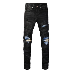 Men's slim fit black distressed jeans with blue striped patchwork and ripped details