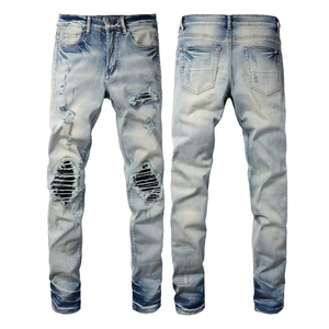 Slim fit retro distressed blue jeans for men with ripped patches and washed texture