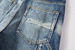 Detail of washed faded denim jeans with orange contrast stitching and rear pocket design