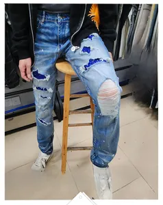 Detail of light blue washed denim with distressed holes and blue sequin patch lining