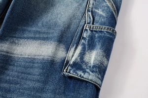 Detail of washed denim pocket with contrast stitching and vintage distressed texture