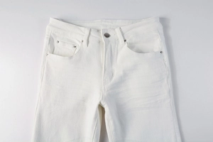 Detailed view of white denim waistline with metal button, zipper fly and rivet pockets
