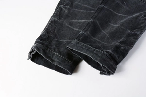 Détail de l'ourlet plié et texture délavée sur un jean noir vintage droit