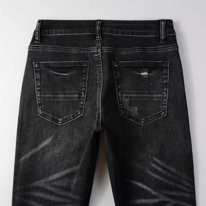 Detail of vintage washed black denim jeans showing back pockets and distressed texture