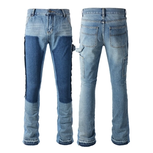 Detail view of denim jeans featuring distressed double knee panels and frayed raw edges