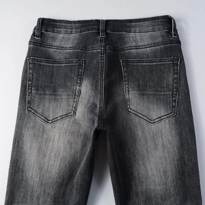 Détails de l'arrière du jean noir délavé montrant les poches et l'effet usé du tissu