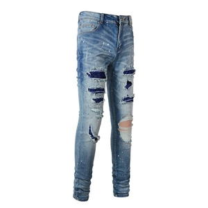 Slim fit light blue distressed jeans with paint splatters and sequin patch details