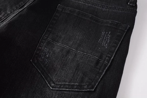 Detailed macro view of retro distressed back pocket on black washed street jeans