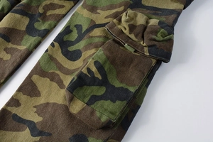 Detailed macro view of camo cargo pants featuring a reinforced side flap pocket