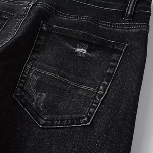 Close-up of distressed denim pocket with washed texture and handmade rip details