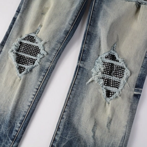 Jean homme bleu style high street avec patchs en strass et genoux déchirés tendance