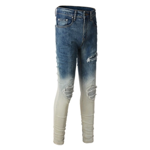 Detail of slim-fit men's jeans with vintage blue gradient wash and ripped knee texture