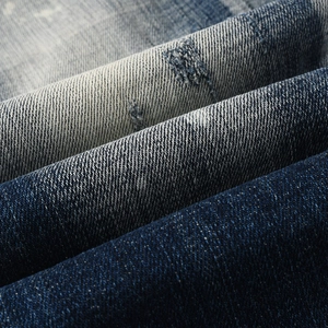 Macro detail of twill weave denim fabric with vintage blue wash and faded texture