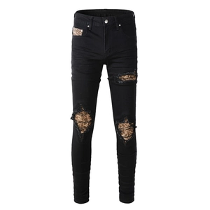 Men's black slim fit distressed jeans featuring gold sequin patches and street style rips