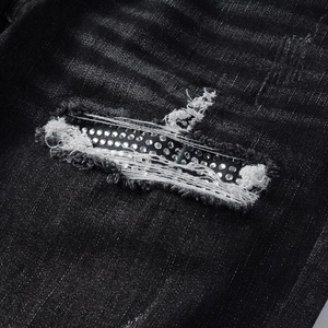 Macro shot of street style ripped denim jeans with sparkling rhinestone patch details