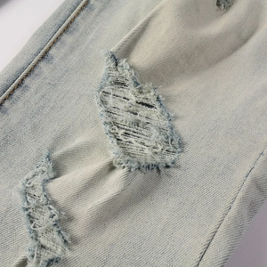 Primo piano dettagliato del tessuto denim invecchiato con bordi sfilacciati e texture