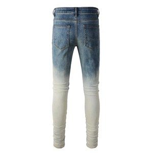 Close-up of slim-fit men's blue to white gradient jeans with distressed wash and stacked leg