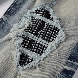 Gros plan sur un jean bleu délavé avec des strass étincelants sur doublure en maille noire