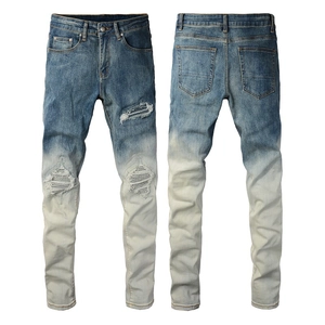 Detailed close-up of distressed ripped knees and blue gradient wash on slim fit denim jeans