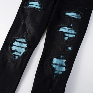 Men's slim fit black distressed jeans with blue corduroy patches and frayed edges
