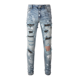 Slim fit light blue jeans with heavy distressed holes, silver rhinestones and white paint splashes