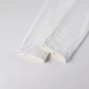 Close-up of white slim fit men's denim trousers showing twill fabric and hem details