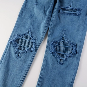 Jean bleu ajusté pour homme avec déchirures stylées en forme de losange au niveau des genoux