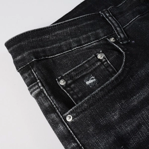 Detail shot of men's distressed grey denim jeans featuring metal rivets and pocket texture