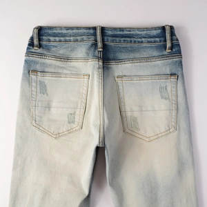 Dettaglio posteriore di jeans lavati azzurri con tasche distressed e toppe decorative di stile