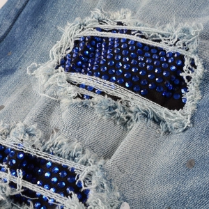 Men's slim fit distressed blue jeans with rhinestone patches and paint splatters