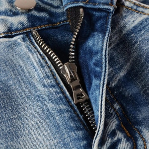 Detailed close-up of retro washed denim fly with premium metal zipper and golden stitching
