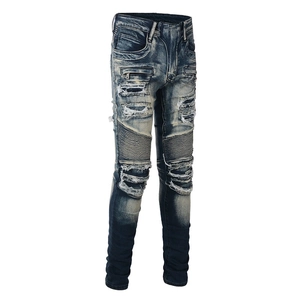Macro detail of men's blue biker jeans showing distressed whiskers and ribbed paneling