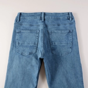 Détail des poches arrière et de la taille d'un jean avec surpiqûres et délavage