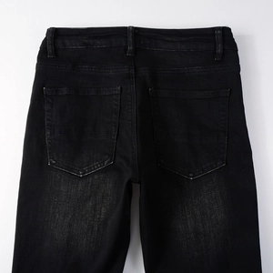 Detail of slim fit black denim jeans showing back pockets and washed texture finish