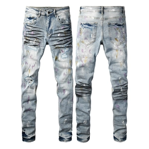Slim fit men's distressed denim jeans with paint splatter and biker pleated details