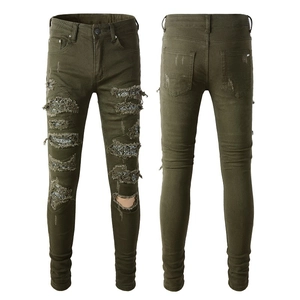 Dettaglio dei jeans slim fit verde militare con fodera paisley sulle zone dei fori strappati