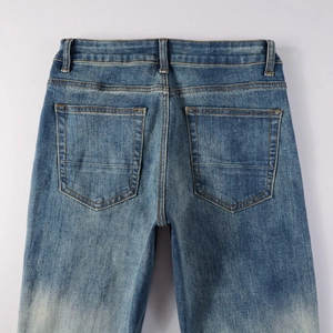 Detailed view of men's vintage washed blue jeans featuring back pockets and fading effects
