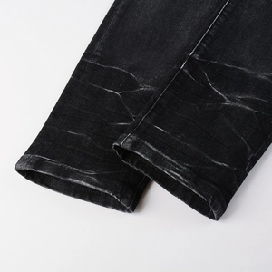 Close-up of the washed black denim hem featuring vintage textures and clean stitching