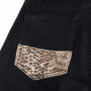 Detail of black men's denim jeans with a leopard print patch on the back pocket