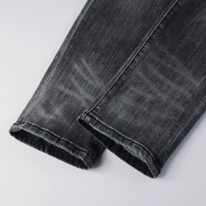 Gros plan de l'ourlet en jean gris foncé délavé avec texture vintage et coutures