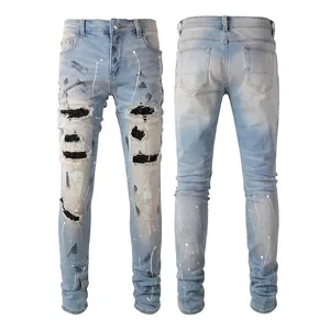 Detailed view of light blue distressed slim fit jeans with paint splatter and patches