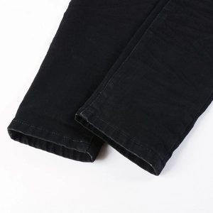 Close-up of black denim jeans hem showing high-quality stitching and twill texture