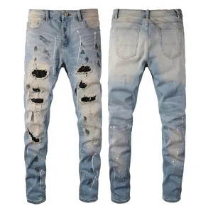 Men's slim fit light blue distressed jeans with paint splatters and denim patches